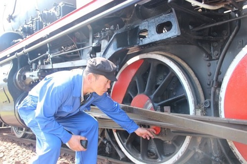 Engineer Tran Dinh Hung, chairman of the recovery project, inspects the locomotive following the trial run.