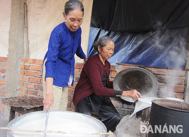 Bà Túy Phong (đứng) và bà Đặng Thị Tùng, hai hộ đầu tiên làm bánh tráng theo quy chuẩn mới của làng nghề Túy Loan. Ảnh: H.L