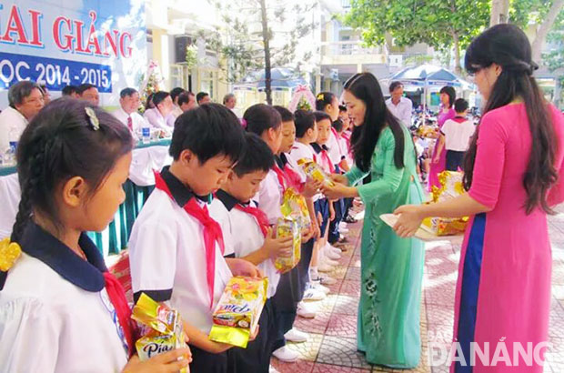 Cô Bùi Thị Bình, Hiệu trưởng Trường tiểu học Bế Văn Đàn trao quà cho học sinh nghèo.