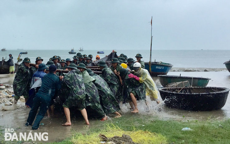 Bộ đội Biên phòng thành phố Đà Nẵng giúp dân di chuyển phương tiện lên bờ để tránh bão, Ảnh: Hồ Sỹ Quý