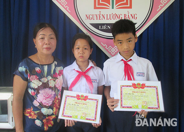 Bà Nguyễn Thị A trao học bổng cho các em học sinh. 