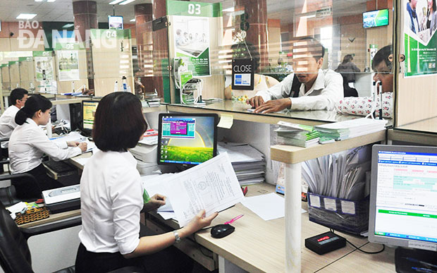 Các ngân hàng cho biết, họ sẽ đáp ứng đủ nhu cầu ngoại tệ hợp lý cho khách hàng dịp Tết.  Trong ảnh: Khách hàng đang giao dịch tại Vietcombank Đà Nẵng.