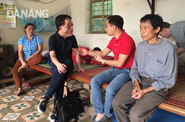 Adam Henry Pearson (thứ 2, từ trái) tiếp xúc với một gia đình nạn nhân da cam ở Đà Nẵng trong chuyến đi. Ảnh: P.T