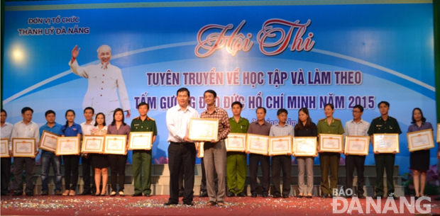Trưởng ban Tuyên giáo Thành ủy Nguyễn Thanh Quang trao Bằng khen cho các đơn vị đoạt giải tại Hội thi tuyên truyền về học tập và làm theo tấm gương đạo đức Hồ Chí Minh năm 2015. 	 Ảnh: GIA HUY