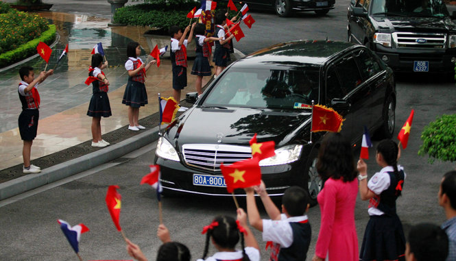 Trẻ em thủ đô vẫy cờ chào đón đoàn xe của Tổng thống François Hollande - Ảnh: REUTERS