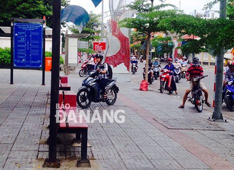 Nhiều phương tiện lưu thông từ đường Lê Duẩn về đường Trần Phú buộc phải chạy xe lên vỉa hè mới đi được.