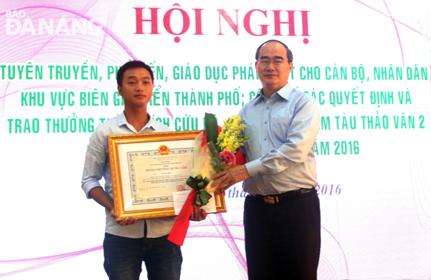 Thừa ủy nhiệm Chủ tịch nước, Chủ tịch Ủy ban MTTQ Việt Nam Nguyễn Thiện Nhân trao Huân chương Dũng cảm cho thuyền viên Lê Văn Hoa.  