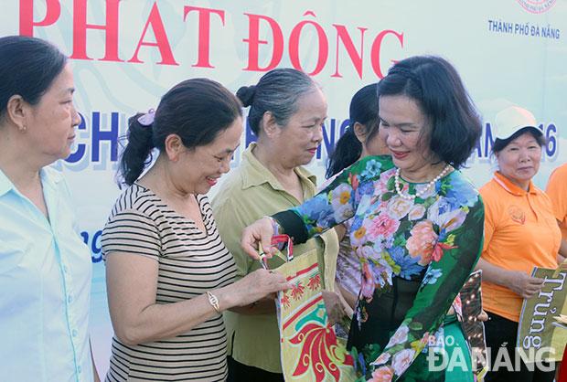 Chủ tịch Hội LHPN thành phố Nguyễn Thị Thu Hà trao túi đi chợ may bằng bạt hiflex nhằm phát động phong trào sống xanh trong hội viên phụ nữ. Ảnh: NGỌC HÀ