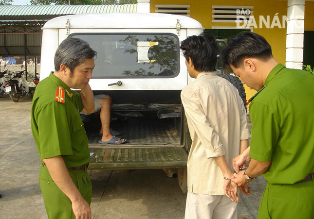 Thượng tá Bùi Quang Hùng (bên trái, lúc công tác ở Phòng Cảnh sát Hình sự) kiểm tra đối tượng trước khi chuyển vào trại tạm giam.