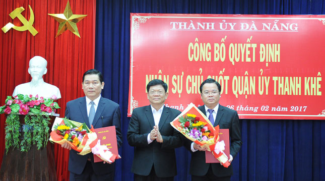 Phó Bí thư Thường trực Thành ủy Võ Công Trí trao quyết định và tặng hoa chúc mừng đồng chí Nguyễn Thanh Quang (bìa trái) và đồng chí Lê Minh Trung (bìa phải)