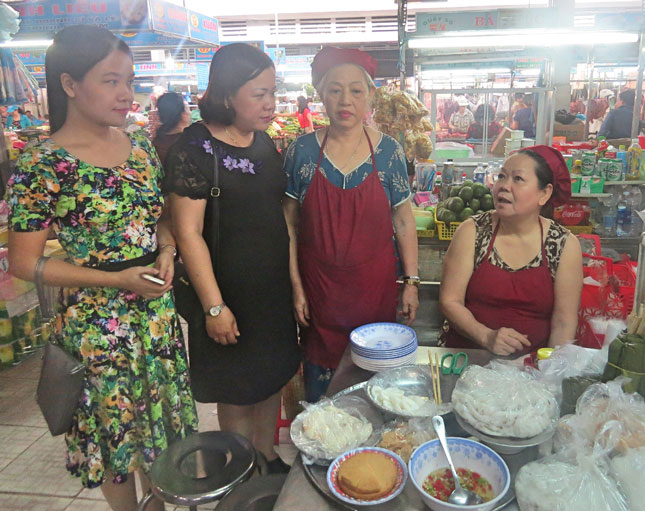 Cán bộ Hội Liên hiệp Phụ nữ quận Hải Châu thực hiện công tác giám sát, nhắc nhở hội viên buôn bán bảo đảm an toàn vệ sinh thực phẩm tại chợ Mới (đường Hoàng Diệu).