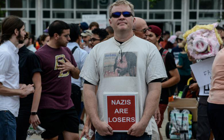 Một người biểu tình cầm tấm biển ghi “Phát xít mới là những kẻ thua cuộc”.
