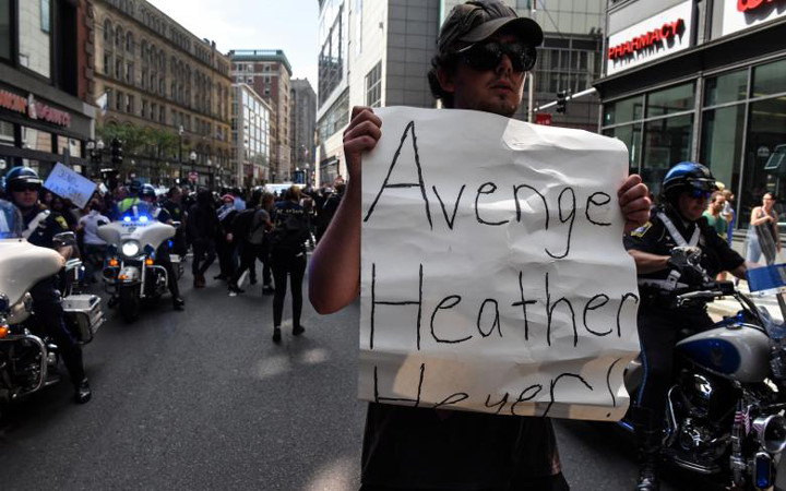 Một người biểu tình cầm biểu ngữ ghi “Trả thù cho Heather Heyer” (người phụ nữ chết trong vụ bạo loạn ở Virginia).