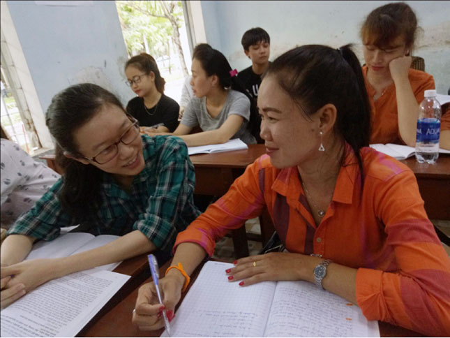Chị Phonexay Thongthavivong (bên phải) trao đổi bài với sinh viên người Việt ở lớp 14SGC của Trường Đại học Sư phạm, Đại học Đà Nẵng.