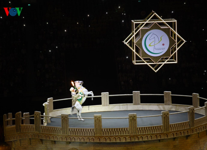 Ngọn đuốc Olympic được một VĐV cưỡi ngựa trắng mang vào sân.
