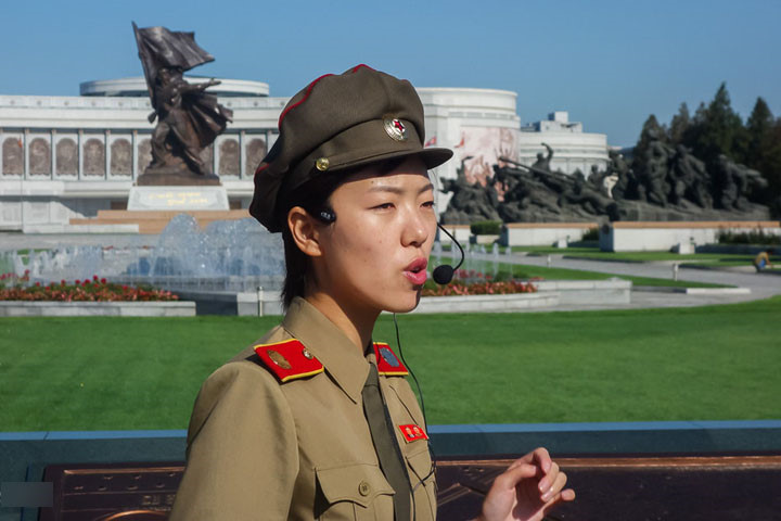 Hướng dẫn viên thuyết minh về Chiến tranh Triều Tiên theo góc nhìn Triều Tiên. Phía sau là “Bảo tàng Chiến tranh Giải phóng Tổ quốc Chiến thắng”.