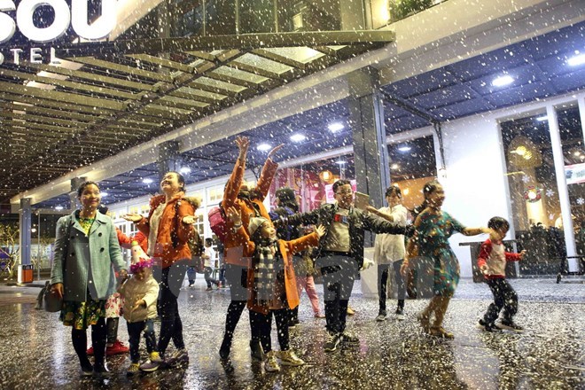 Visitors enjoy artificial snowfall in Da Nang on Christmas holiday (Photo: VNA)