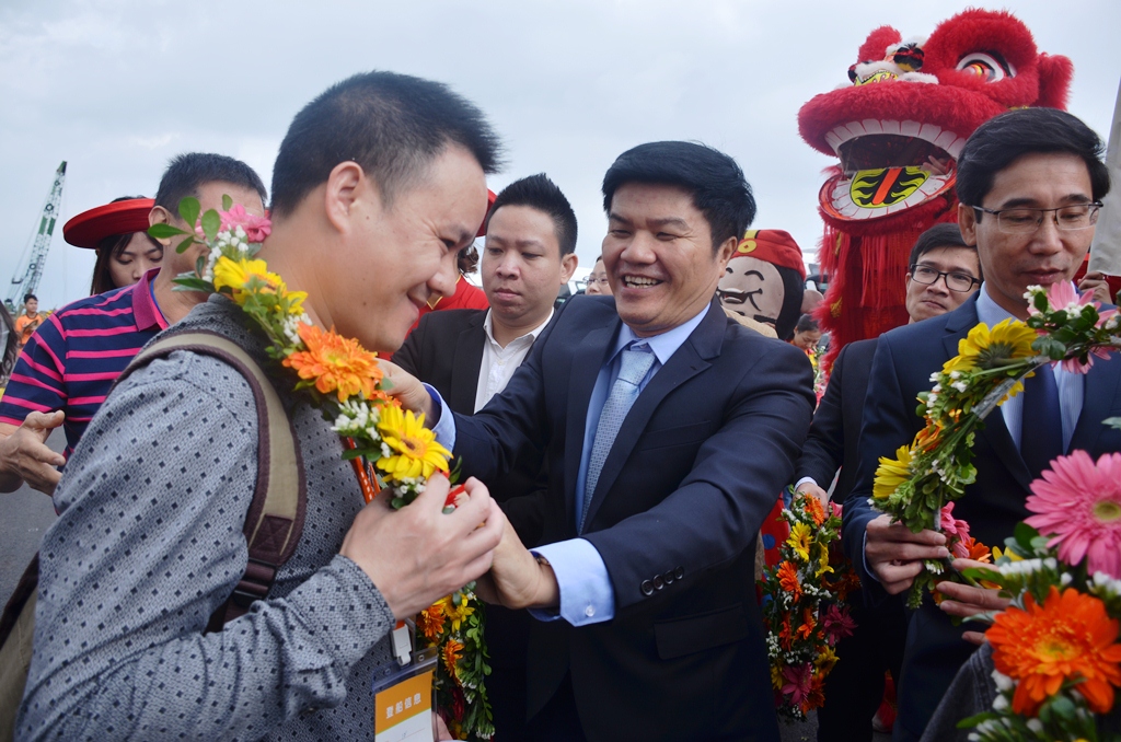 Giám đốc Sở Du lịch thành phố, ông Ngô Quang Vinh (giữa) tặng hoa chúc mừng những vị khách tầu biển đầu tiên xông đất Đà Nẵng dịp năm mới.