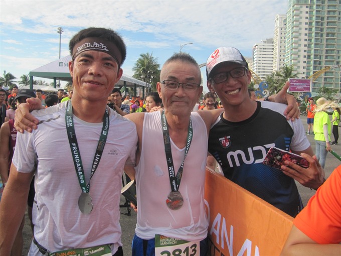 Elated: Vietnamese and Japanese runners celebrate after finishing the half marathon category at the Đà Nẵng marathon in 2017. — VNS Photo Công Thành Read more at http://vietnamnews.vn/sports/421141/da-nang-marathon-opens.html#TQFGW2sYgAAiOzkk.99