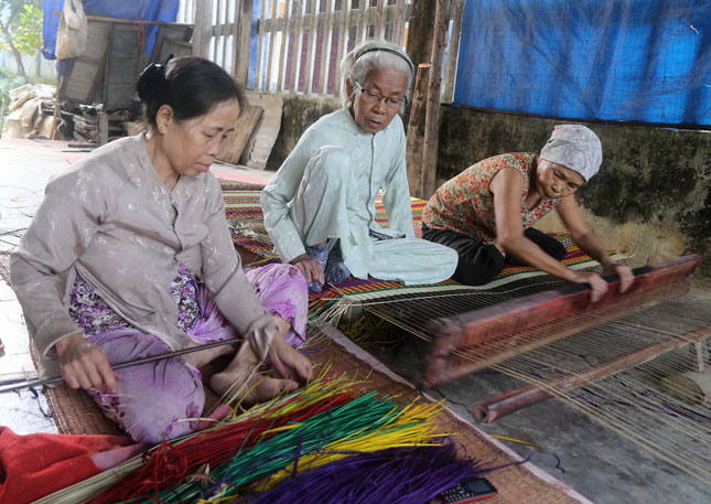 Bà Ngô Thị Thân (giữa) và hai người thợ dệt chiếu “lão làng” của làng chiếu Cẩm Nê. Ảnh: VĂN THÀNH LÊ