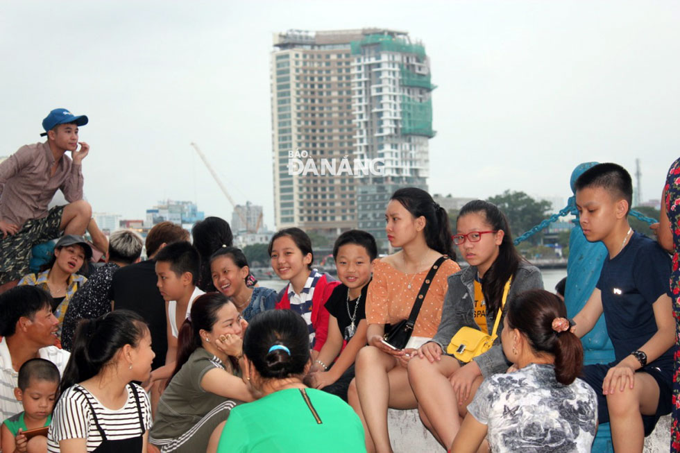 Nhiều người dân tập trung ở vỉa hè đường Trần Hưng Đạo, khu vực ven sông Hàn để xem pháo hoa. Ảnh: KHANG NINH