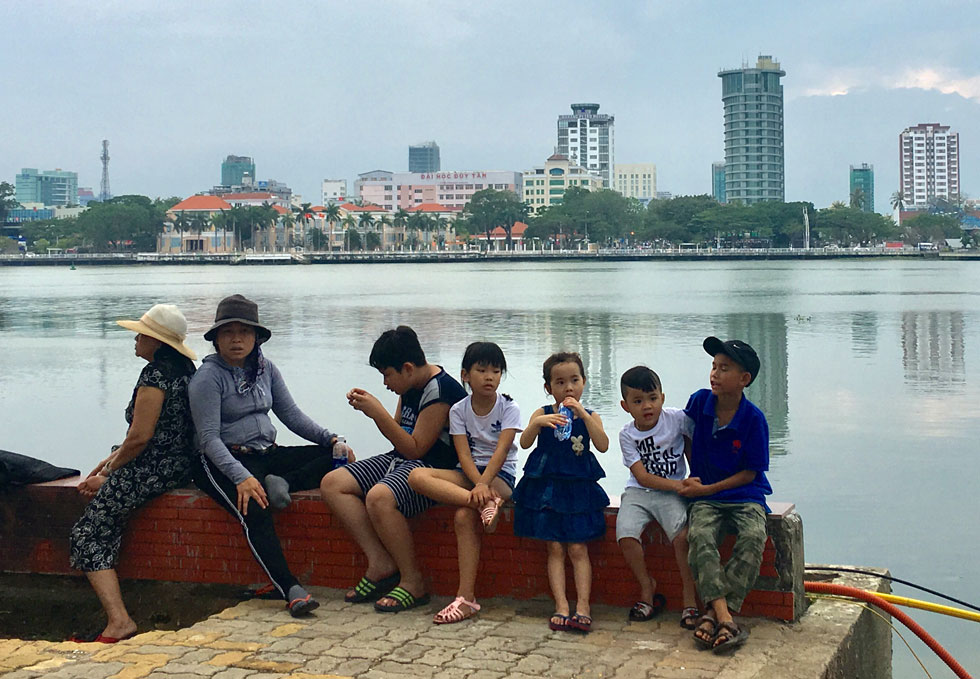 Nhiều gia đình có con nhỏ đã sớm tìm được vị trí tốt ven bờ sông Hàn để chiêm ngưỡng những màn pháo hoa trong đêm khai mạc DIFF 2018. Ảnh: KHANG NINH