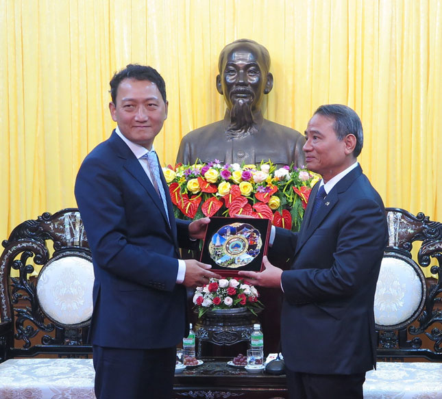 Bí thư Thành ủy Trương Quang Nghĩa (phải) tặng quà lưu niệm cho Đại sứ Kim Do Hyon. Ảnh: SƠN TRUNG