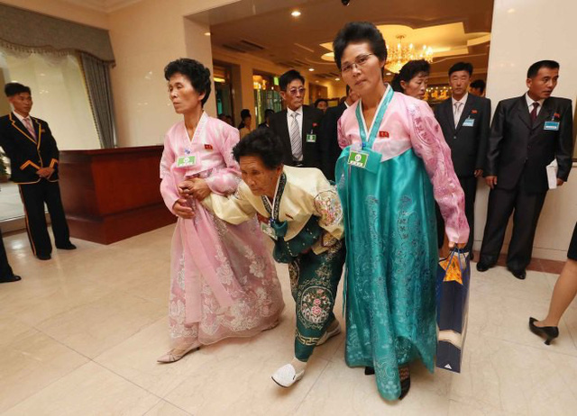 Những phụ nữ Triều Tiên cao tuổi mặc những bộ trang phục truyền thống hanbok với màu sắc rực rỡ, run rẩy bước đi với sự hỗ trợ của các thân nhân.