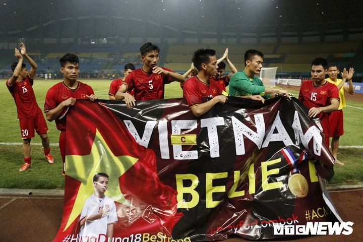 Đó là một bức hình có in ảnh tiền vệ Đỗ Hùng Dũng, người vừa chia tay Olympic Việt Nam vì chấn thương, trên nền cờ đỏ sao vàng kèm thông điệp chúc đồng đội mau bình phục.