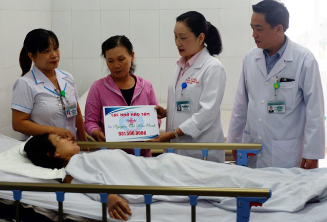 A representative from the Da Nang General Hospital presenting 931 million VND to Mrs Oanh, one of 4 lucky survivors of a deadly road traffic crash in Quang Nam Province