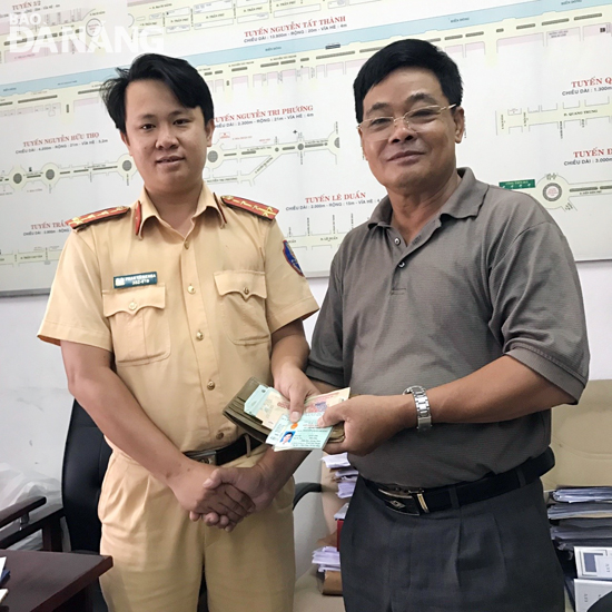 Captain Khoa (left) returning the lost property to Mr Hoang
