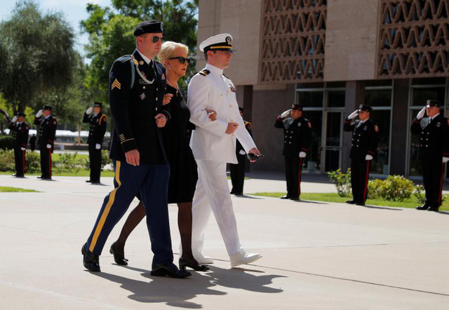 Bà Cindy McCain, phu nhân cố Thượng nghị sĩ John McCain, cùng hai con trai James (trái) và John (phải) đi theo sau linh cữu tiến vào tòa nhà nghị viện Arizona.