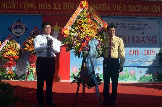 Deputy Secretary Tri presenting a wreath of flowers to the Dam Quang Trung Junior High School representative