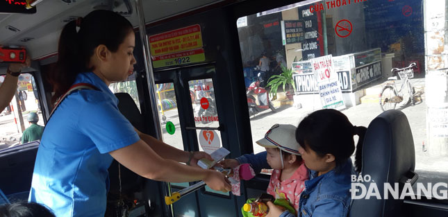 A bus employee selling tickets to passengers onboard 