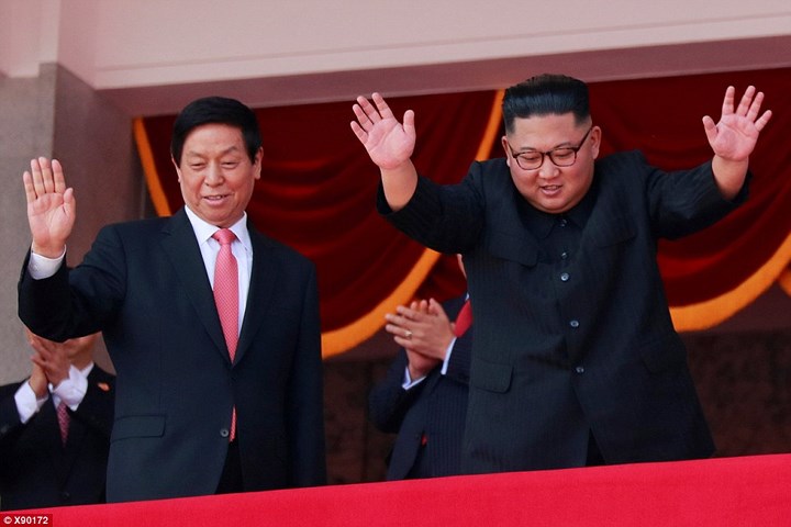 Ông Kim Jong-un và ông Lật Chiến Thư đứng trên khán đài vẫy tay chào người dân. Ảnh: Dailymail. Ảnh: Dailymail.