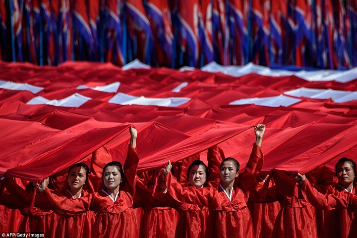 Những thiếu nữ Triều Tiên xinh đẹp trong trang phục màu đỏ mang theo biểu ngữ. Ảnh: AFP/Getty.