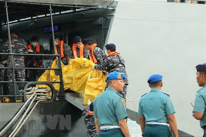 Rescuers gather debris of crashed plane and body parts of the victims (Photo: VNA)