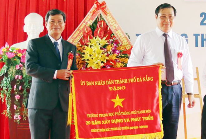 Phó Bí thư Thành ủy, Chủ tịch UBND thành phố Đà Nẵng Huỳnh Đức Thơ (bên phải) tặng Cờ của UBND thành phố cho Trường THPT Ngũ Hành Sơn vì những thành tích đạt được trong 20 năm xây dựng và phát triển