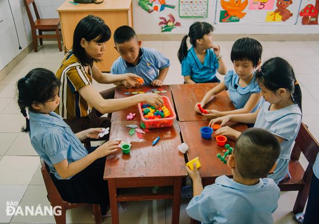Teacher Nguyen Thi Thu Thao instructing her pupils to play puzzle to help them increase their creativity.