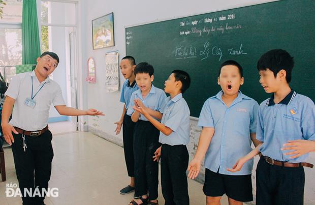 Teacher Le Quang Hai (born in 1989) teaching his pupils learn to sing.