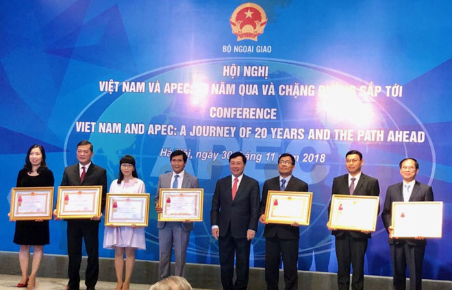 On behalf of the authorities and citizens of Da Nang, municipal People's Committee Vice Chairman Ho Ky Minh(2nd, right)  receiving a second-class Labour Medal from the State President.