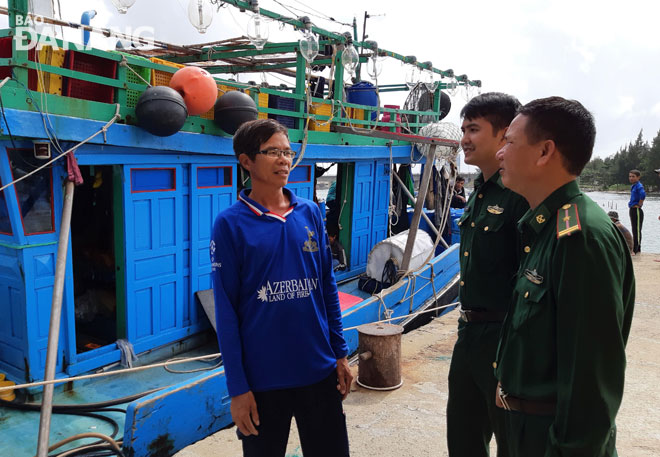 Bộ đội Biên phòng đồn Sơn Trà trò chuyện, động viên ngư dân trước khi ra khơi. Ảnh: Lam Phương