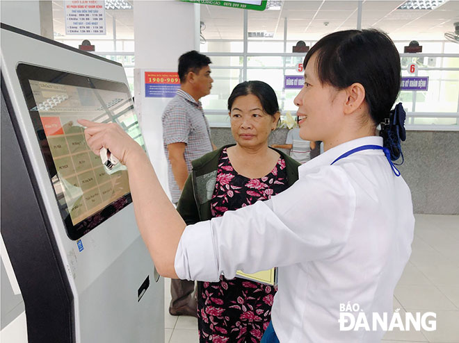 Bệnh viện Đà Nẵng đã triển khai đồng bộ nhiều giải pháp nhằm nâng cao chất lượng khám chữa bệnh, hướng đến sự hài lòng của khách hàng. Trong ảnh: Người bệnh có thẻ BHYT ban đầu tại bệnh viện được hỗ trợ sử dụng máy đăng ký khám bệnh tự động.