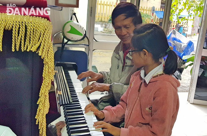 Nhạc sĩ Nguyễn Văn Tám cùng cháu thư giãn với đàn piano.