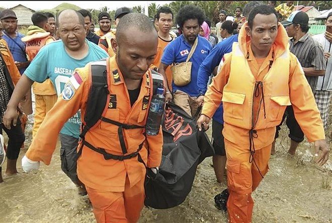 Rescuers carry the body of a flood victim (Photo: VNA)