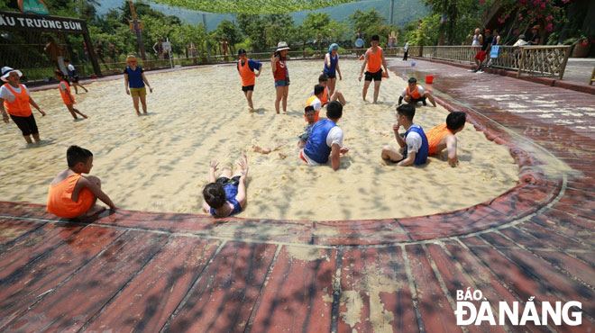 Visitors having fun time in a mud arena at the Nui Than Tai Hot Spring Park 