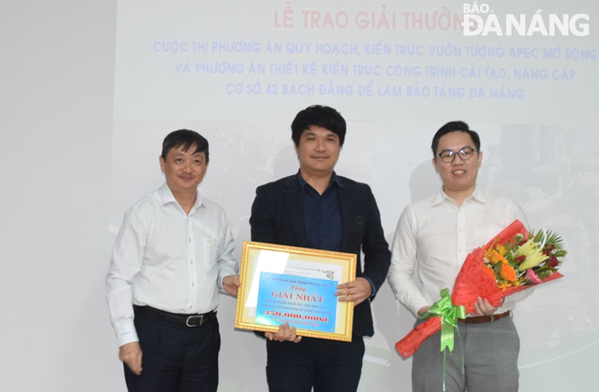 On behalf of the contests’ organizers, Vice Chairman of the municipal People’s Committee Dang Viet Dung (left) presenting the first prize to the studioMilou Singapore