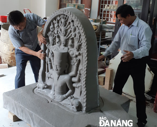Two experts getting involved in making a version of the Siva statue at the Museum of Cham Sculpture