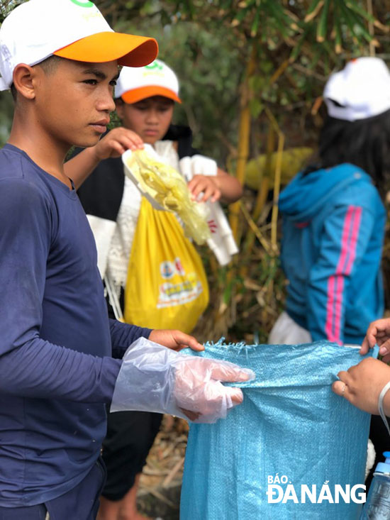 Các em học sinh trong dự án “Em nuôi” tham gia dọn rác trên bán đảo Sơn Trà.  (Ảnh: Hội Tình nguyện Chung tay vì cộng đồng cung cấp)