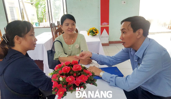 Cán bộ BHXH huyện Hòa Vang (phải) tư vấn chính sách BHXH tự nguyện.